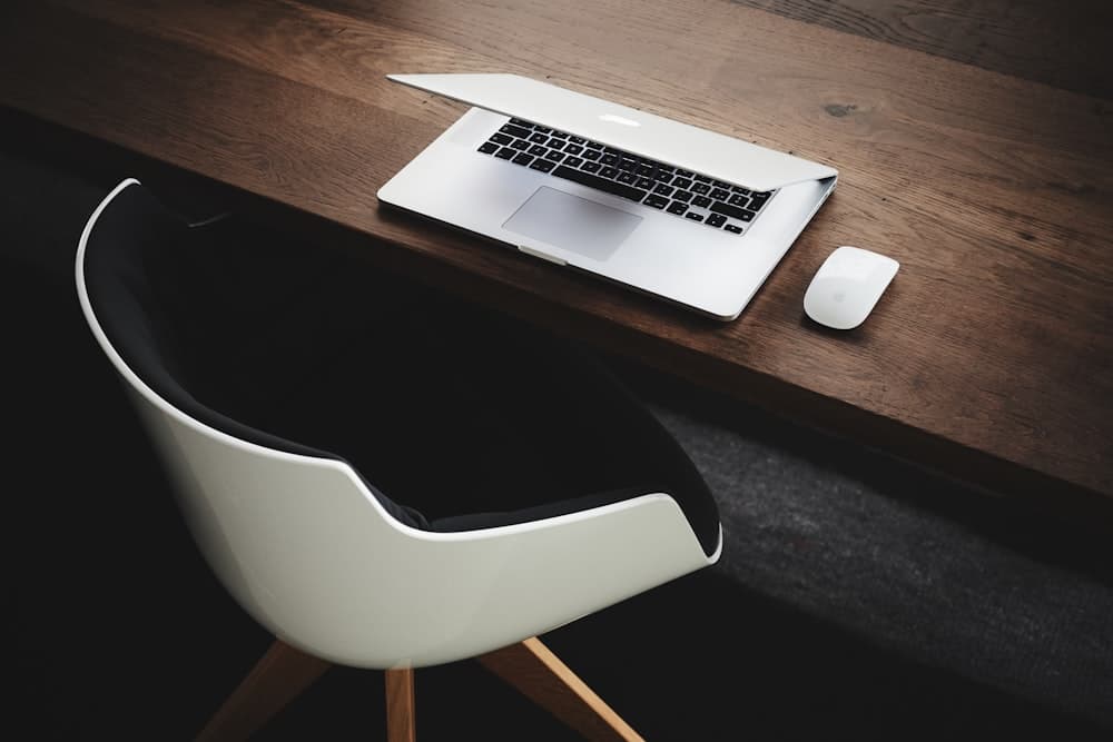 Minimal wood desk with laptop and lamp near a window